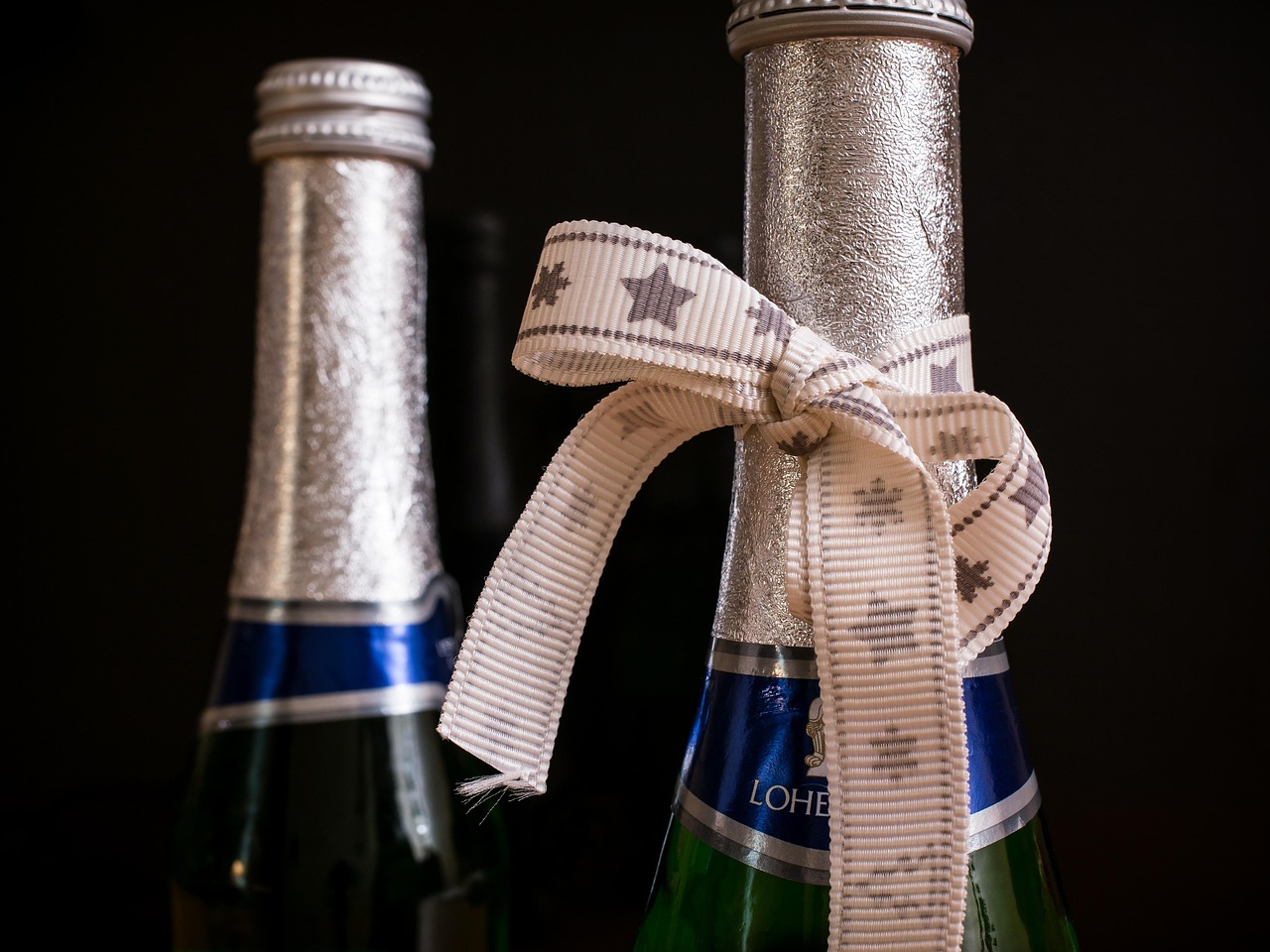 Canada duty-free allowance for visitors: two bottle necks tied with a ribbon bow on a dark background
