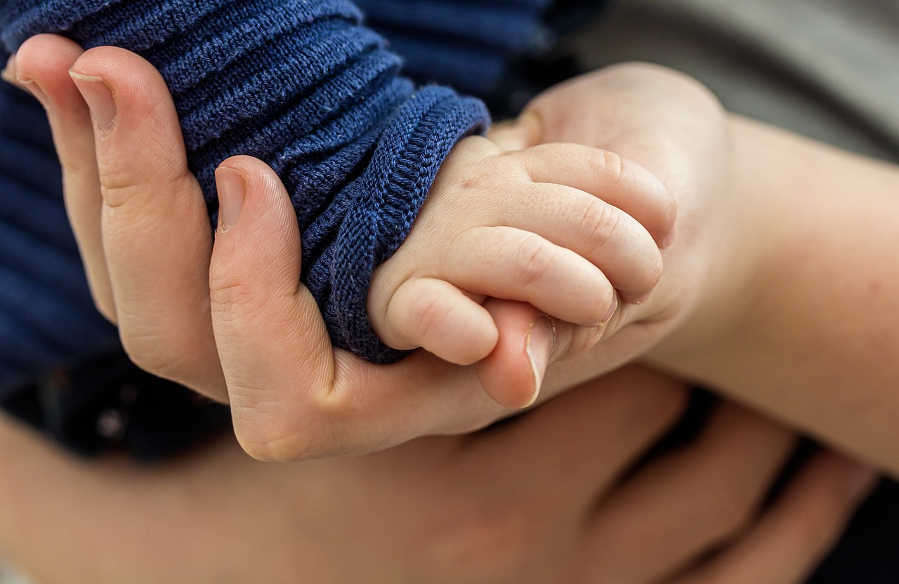 Consent letter for a child travelling to Canada: a toddler's small hand held in an adult's hand