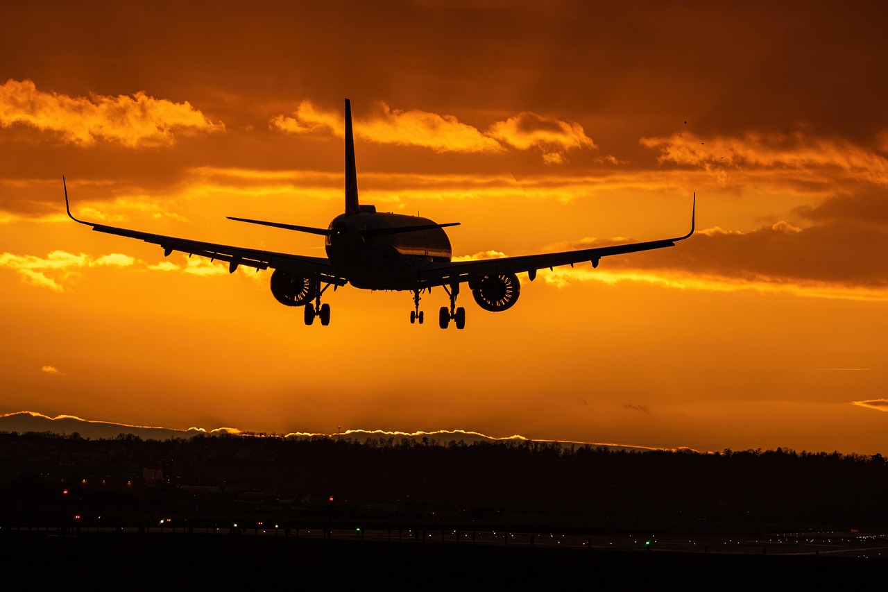Canada eTA after a cancelled or rebooked flight: an airliner in silhouette coming in to land against an orange sunset sky