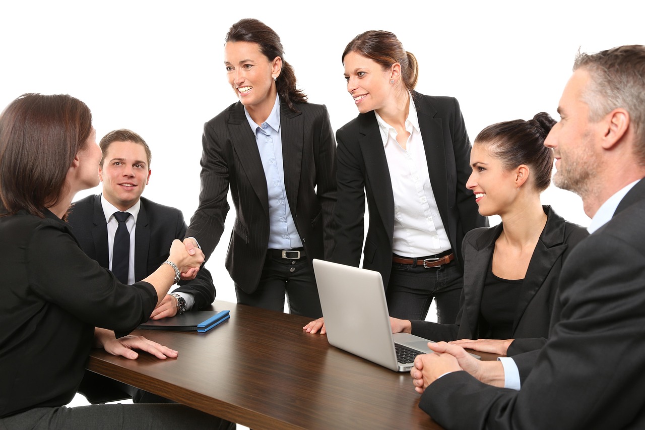 Canada eTA for a Business Trip or Meetings: coworkers shaking hands around an office table during a business meeting