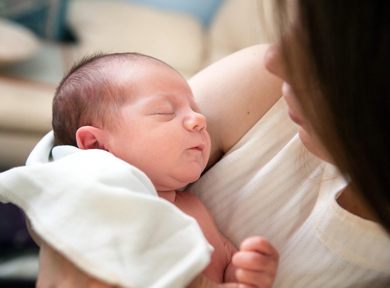 Canada eTA for a Baby or Newborn: Do Kids and Infants Need One?: sleeping newborn baby held in a mother's arms