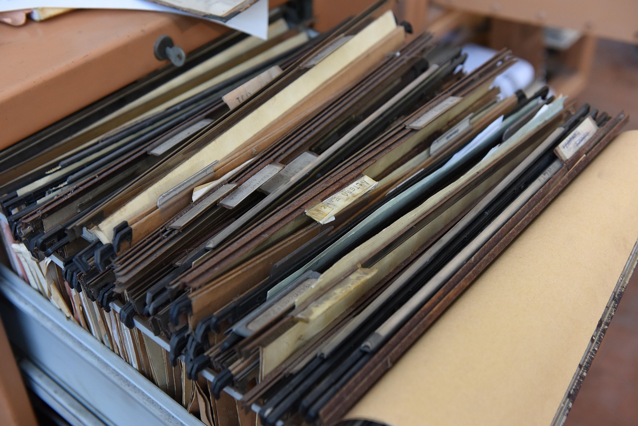 Canada eTA document upload problems: a drawer of hanging file folders packed with paper documents, seen close up