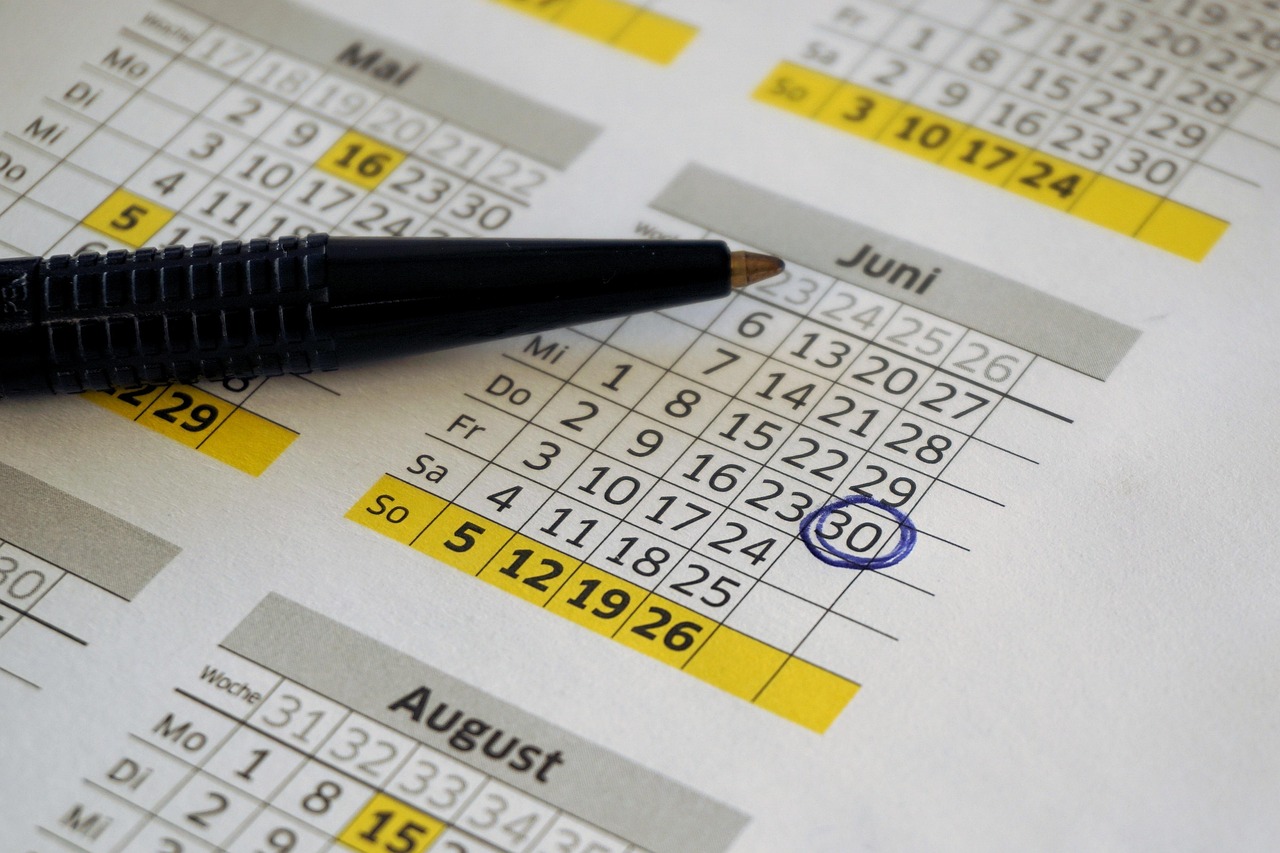 Rescheduling a Canada trip with an eTA: a paper calendar with one date circled in blue pen and a pen resting beside it